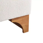 Sillón Homy Casa con respaldo enrollado y base de madera maciza, tapicería de bouclé