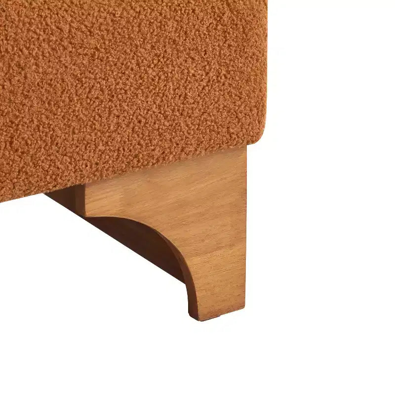Sillón Homy Casa con respaldo enrollado y base de madera maciza, tapicería de bouclé